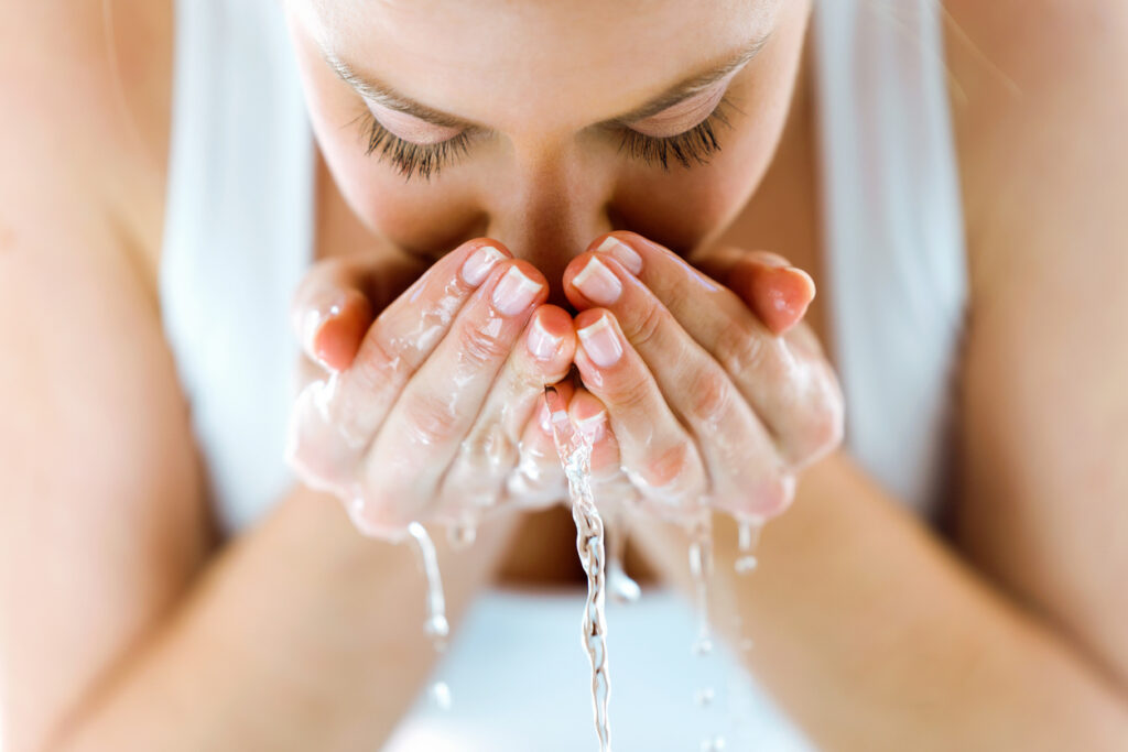 A woman washing her face with clear water